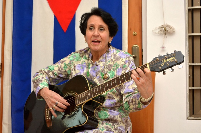 Madame Concepción, wife of Cuban Ambassador, Jesús Zenén Buergo Concepción, playing guitar and singing at the art exhibit by 30 Cuban artists in Islamabad.