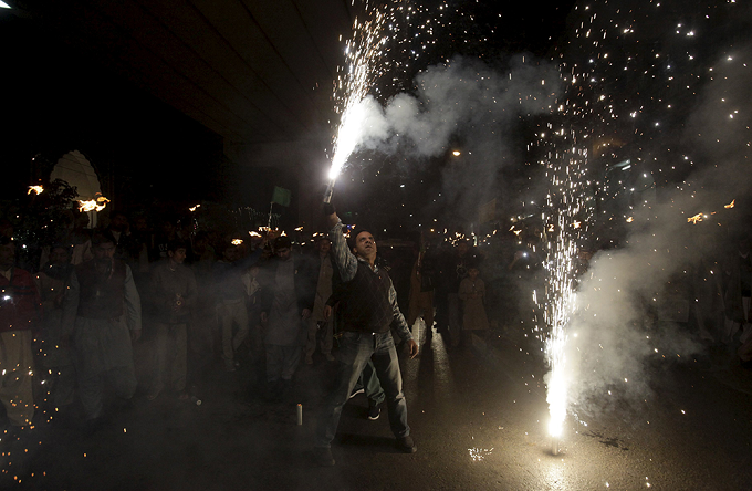A man lights fireworks during a procession ahead of Eid-e-Milad-ul-Nabi celebration in Lahore.