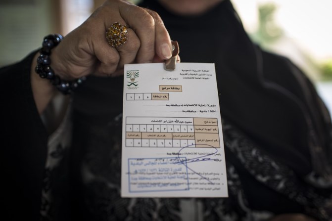 A woman holds up her election card, which is No. 1, indicating that she was the first to sign up at voting registration at a girls high school in North Jeddah on Saturday. MONIQUE JAQUES FOR THE WALL STREET JOURNAL