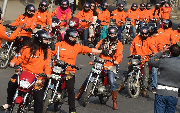 Women participants of Women on Wheels (WOW) prepare to ride their motorbikes during a rally launching the Women on Wheels campaign in Lahore on January 10, 2016.─ AFP.
