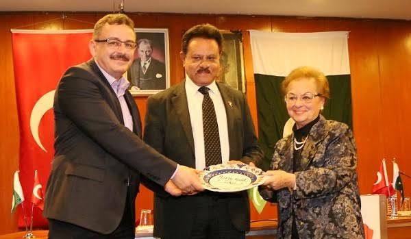 Ms. Ulay and Dr. Junaid presenting a commemorative shield to Prof. Dr. Halil