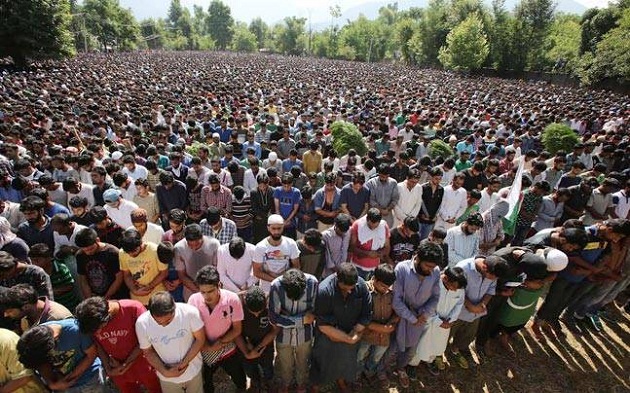 Tens of thousands of people defied curfew in Kashmir on Saturday to pay homage to Burhan Wani and attend his funeral.