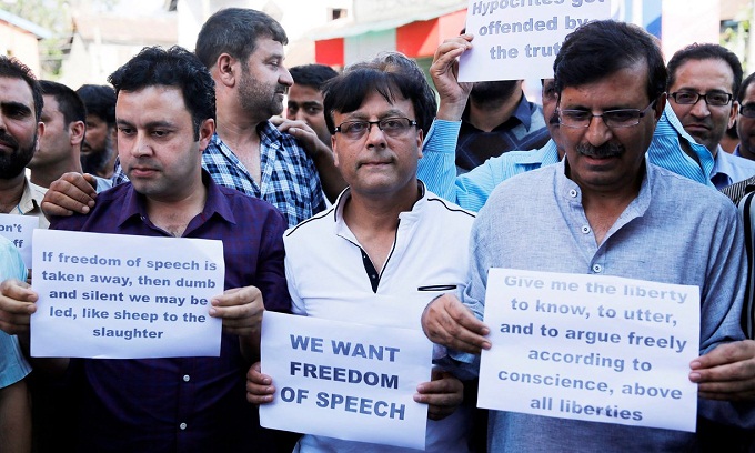  Kashmiri journalists hold placards during a protest in Srinagar on Tuesday. India banned publication of newspapers in the disputed territory for three days and raided newspaper offices. Photograph: Farooq Khan/EPA