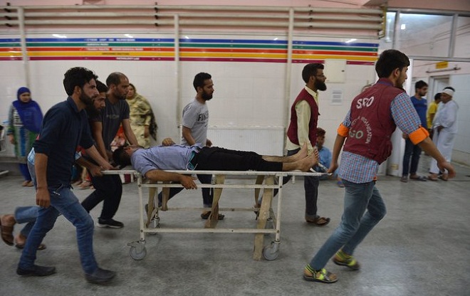 Volunteers at a hospital assisting an injured youth who was shot during clashes between security forces and protesters in Srinagar on Sunday. Hospitals received more than 400 injured, and at least 19 have died in the violence. Photo: Tauseef Mustafa/AFP/Getty Images