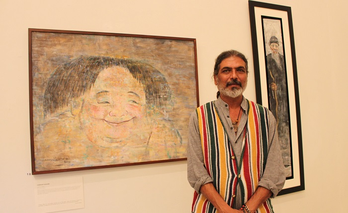 Pakistani artist Farrukh Shahan with his paintings at joint exhibition by Pakistani and Chinese artists at PNCA in Islamabad on 18 Oct. 2016. Photo: Sana Jamal