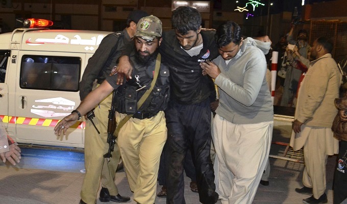 Rescuers help an injured person to a hospital in Quetta, Pakistan, after a hostel for police cadets was attacked by militants. Photograph: Arshad Butt/AP