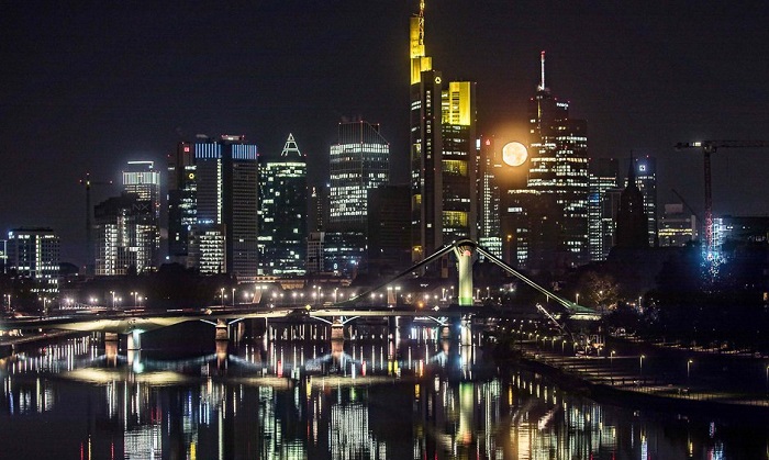 Full moon sets behind the banking district in Frankfurt am Main, western Germany. Photo: AFP