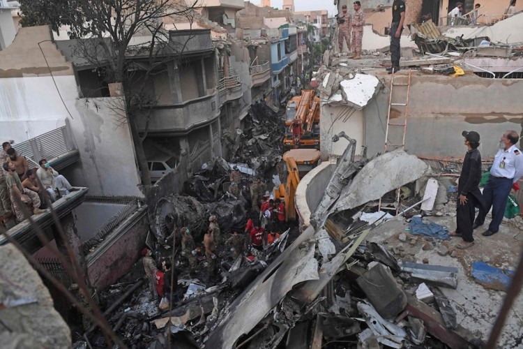Security personnel search for victims in the wreckage of a Pakistan International Airlines aircraft after it crashed in a residential area in Karachi on May 22. Photo: AFPSecurity personnel search for victims in the wreckage of a Pakistan International Airlines aircraft after it crashed in a residential area in Karachi on May 22. Photo: AFP
Security personnel search for victims in the wreckage of a Pakistan International Airlines aircraft after it crashed in a residential area in Karachi on May 22. Photo: AFP