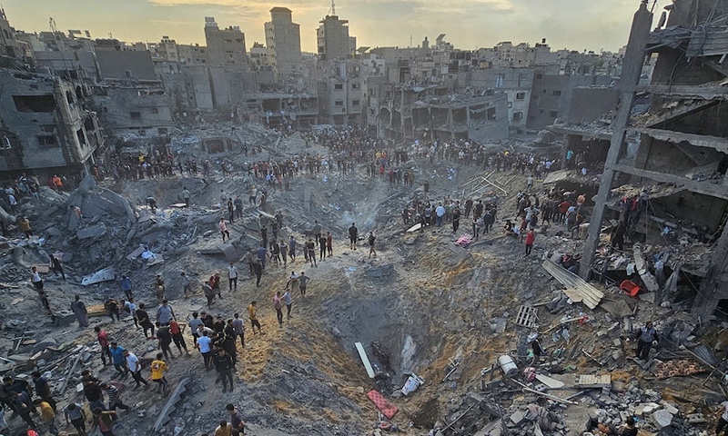 Palestinians search for casualties at the site of Israeli strikes on houses in Jabalia refugee camp in the northern Gaza Strip
